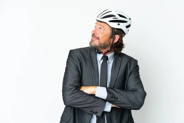 Business senior man with a bike helmet isolated on white background with arms crossed and happy