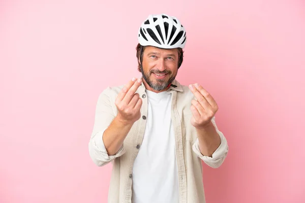 Senior Dutch Man Bike Helmet Isolated Pink Background Making Money — стоковое фото