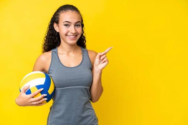 Young Woman Playing Volleyball Isolated Yellow Background Pointing Finger Side — стоковое фото