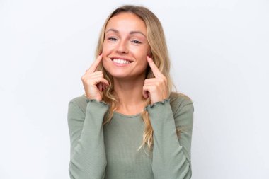 Beyaz arka planda izole edilmiş genç bir Rus kadın mutlu ve hoş bir ifadeyle gülümsüyor.