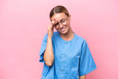 Pembe arka planda izole edilmiş genç doktor kadın gülüyor.