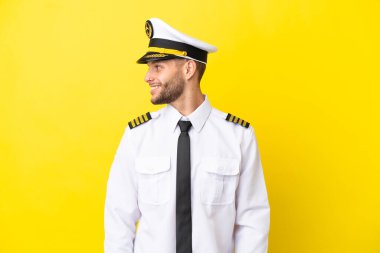 Kafkasyalı pilot sarı arka planda izole edildi.