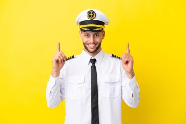 Kafkasyalı uçak pilotu sarı arka planda izole edildi. Harika bir fikir.