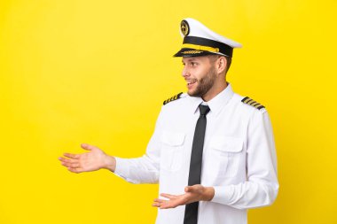 Kafkasyalı pilot, sarı arka planda şaşırmış bir yüz ifadesiyle izole edilmiş.