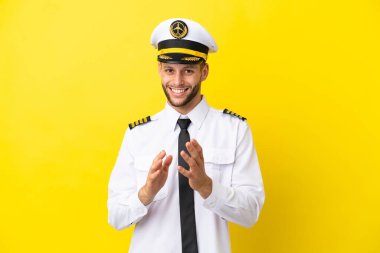 Kafkasyalı pilot sarı arka planda izole edilmiş bir konferansta sunumdan sonra alkışlıyor.