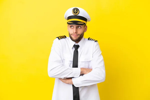 Airplane Caucasian Pilot Isolated Yellow Background Making Doubts Gesture While — Φωτογραφία Αρχείου