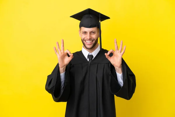 Junge Universitätsabsolvent Kaukasischen Mann Isoliert Auf Gelbem Hintergrund Zeigt Ein — Stockfoto