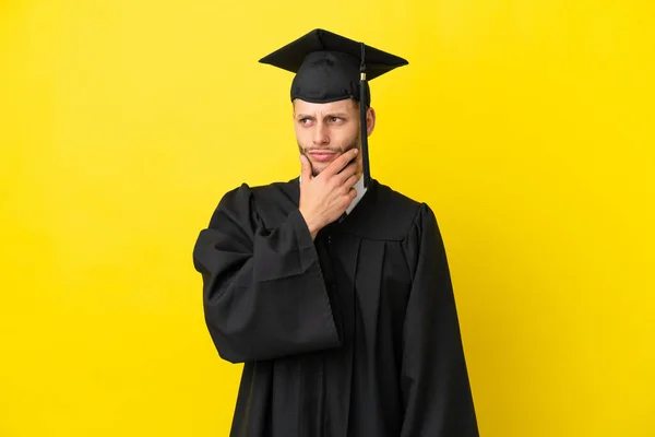 Jonge Universitair Afgestudeerde Blanke Man Geïsoleerd Gele Achtergrond Met Twijfels — Stockfoto