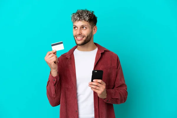 Young Handsome Caucasian Man Isolated Blue Background Buying Mobile Credit — Φωτογραφία Αρχείου