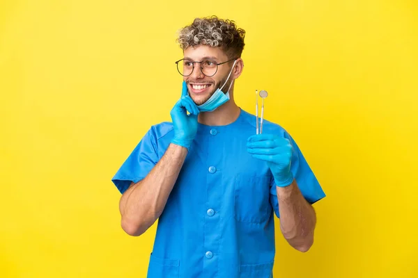 Dentista Caucasiano Homem Segurando Ferramentas Isoladas Fundo Amarelo Pensando Uma — Fotografia de Stock