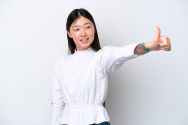 Beyaz arka planda izole edilmiş genç Çinli bir kadın baş parmak işareti yapıyor.