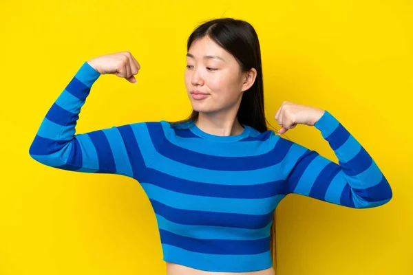 Young Chinese Woman Isolated Yellow Background Doing Strong Gesture — Foto Stock