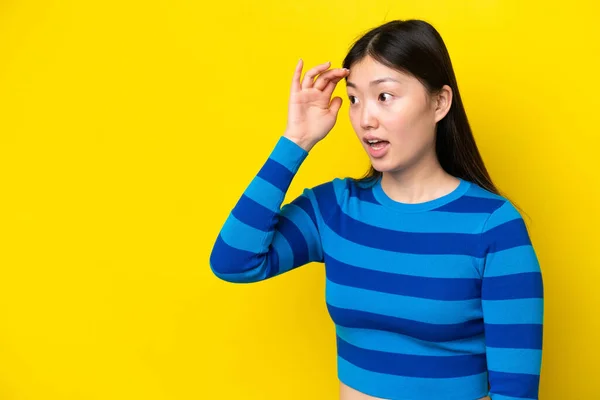 Young Chinese Woman Isolated Yellow Background Surprise Expression While Looking — Stockfoto