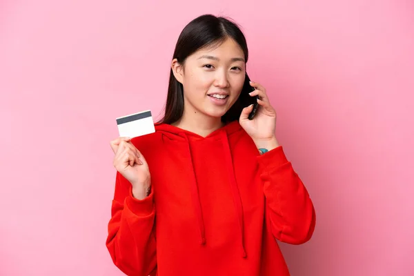 Fiatal Kínai Elszigetelt Rózsaszín Háttér Tartja Beszélgetést Mobiltelefon Kezében Egy — Stock Fotó