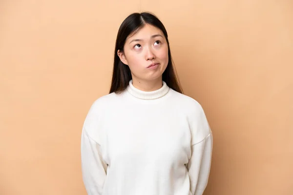 Young Chinese Woman Isolated Beige Background Looking — Fotografia de Stock