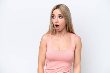 Beyaz arka planda izole edilmiş güzel sarışın kadın yan tarafa bakarken sürpriz jest yapıyor.