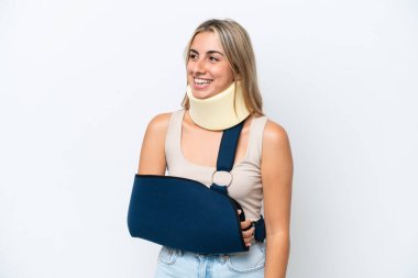 Kırık kollu ve askı takan bir kadın beyaz arka planda izole edilmiş.