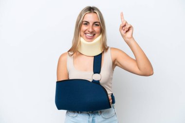 Kırık kollu ve askısı beyaz arka planda olan bir kadın harika bir fikre işaret ediyor.