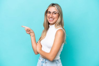 Mavi arka planda izole edilmiş genç, beyaz bir kadın var.