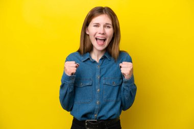 Sarı arka planda izole edilmiş genç İngiliz kadın galibiyeti kutluyor.