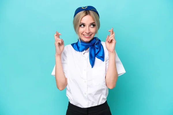 Airplane Blonde Stewardess Woman Isolated Blue Background Fingers Crossing — Stock Photo, Image