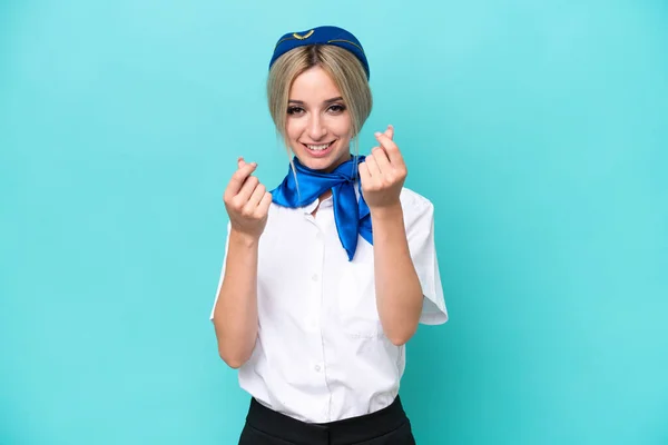 Airplane Blonde Stewardess Woman Isolated Blue Background Making Money Gesture — Zdjęcie stockowe