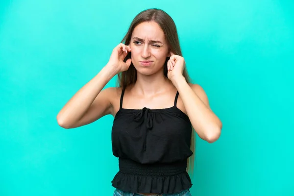 若い白人女性は青の背景に不満とカバー耳に隔離 — ストック写真
