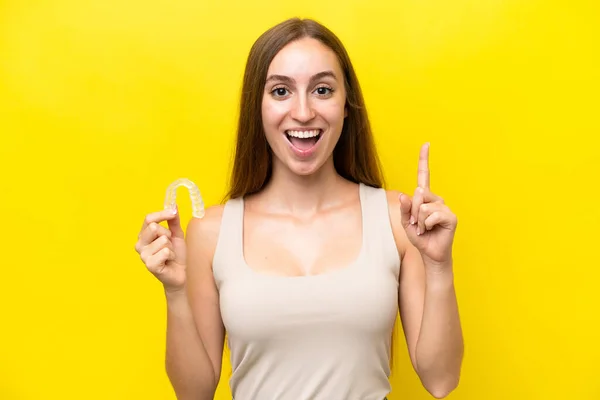 Young Caucasian Woman Holding Invisible Braces Isolated Yellow Background Pointing — Foto Stock