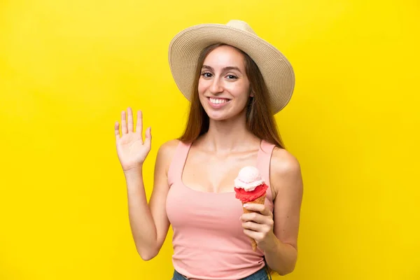 Young Caucasian Cornet Ice Cream Isolated Yellow Background Saluting Hand — Φωτογραφία Αρχείου