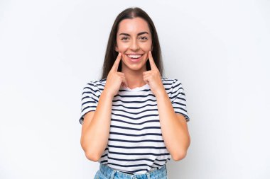 Beyaz arka planda izole edilmiş genç beyaz kadın mutlu ve hoş bir ifadeyle gülümsüyor.