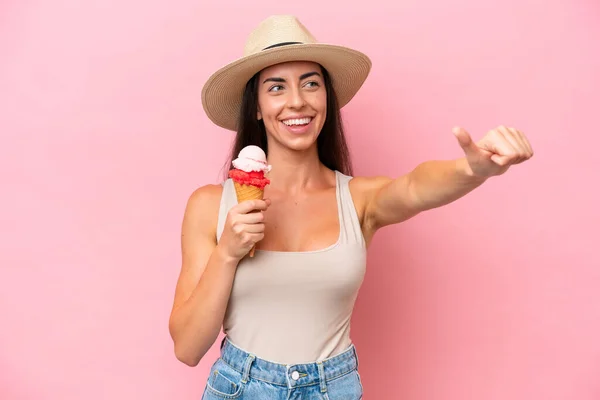 年轻的高加索女人 带着用粉红背景隔开的玉米粒冰淇淋 竖起大拇指做手势 — 图库照片