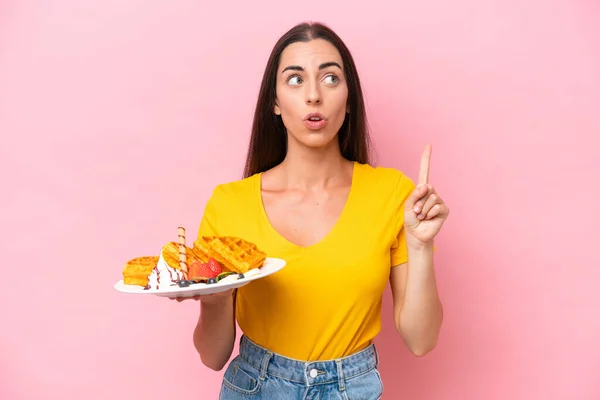 Young Caucasian Woman Holding Waffles Isolated Pink Background Thinking Idea — стоковое фото