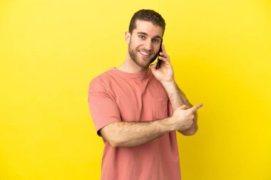 İzole edilmiş arka planda cep telefonu kullanan yakışıklı sarışın adam.