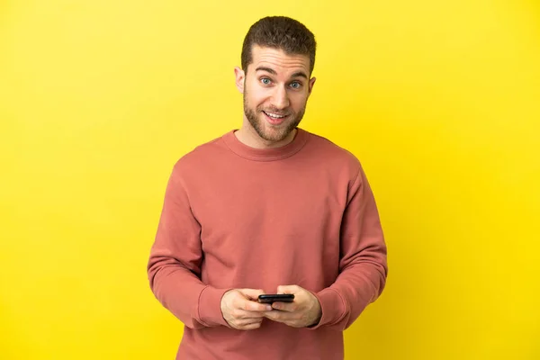 Handsome Blonde Man Isolated Yellow Background Surprised Sending Message — Zdjęcie stockowe