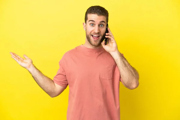 Handsome Blonde Man Using Mobile Phone Isolated Background Shocked Facial — Stock Photo, Image