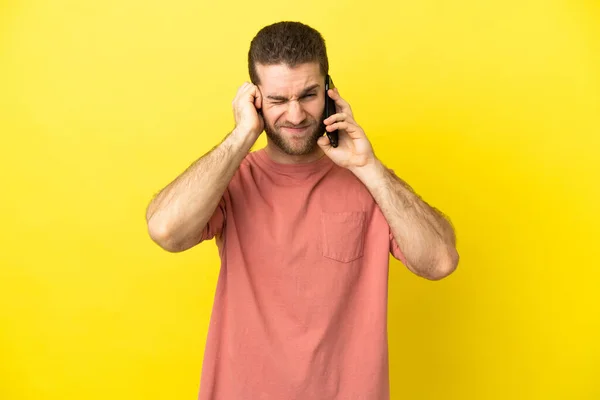 Handsome Blonde Man Using Mobile Phone Isolated Background Frustrated Covering — Zdjęcie stockowe