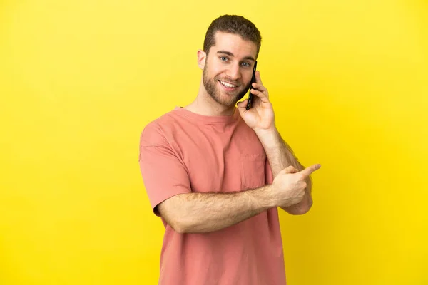 Handsome Blonde Man Using Mobile Phone Isolated Background Pointing Back — 스톡 사진