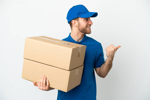 Delivery man over isolated white background pointing to the side to present a product