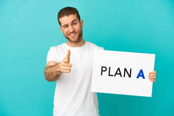 Handsome Blonde Man Isolated Blue Background Holding Placard Message Plan — стоковое фото