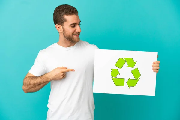 Handsome Blonde Man Isolated Blue Background Holding Placard Recycle Icon —  Fotos de Stock