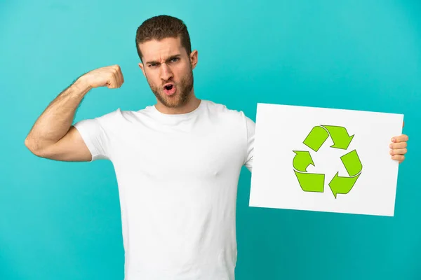 Handsome Blonde Man Isolated Blue Background Holding Placard Recycle Icon — стоковое фото