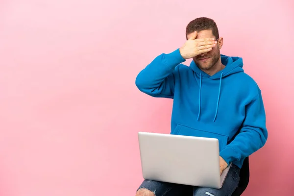 Jovem Sentado Uma Cadeira Com Laptop Cobrindo Olhos Pelas Mãos — Fotografia de Stock