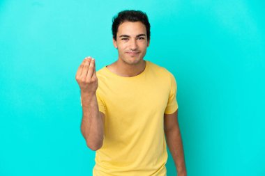 Kafkasyalı yakışıklı adam izole edilmiş mavi arka planda İtalyan jestleri yapıyor.