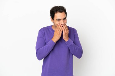 Kafkasyalı yakışıklı adam soyutlanmış beyaz arka planda mutlu ve gülümseyen elleriyle ağzını kapatıyor.