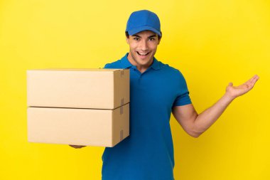 Delivery man over isolated yellow wall with shocked facial expression