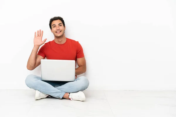 Caucasian Handsome Man Laptop Sitting Floor Saluting Hand Happy Expression — Φωτογραφία Αρχείου