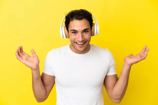 Caucasian Handsome Man Isolated Yellow Background Surprised Listening Music — Φωτογραφία Αρχείου