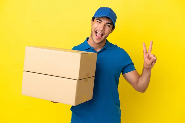 Delivery Man Isolated Yellow Wall Smiling Showing Victory Sign — Stock Photo, Image