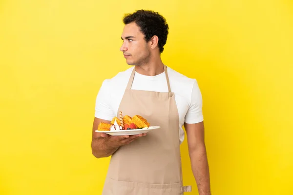 Restaurant Waiter Holding Waffles Isolated Yellow Background Looking Side — Photo