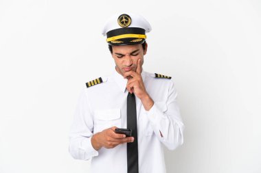 İzole edilmiş beyaz arka plan üzerinde uçak pilotu düşünüp bir mesaj gönderiyor.